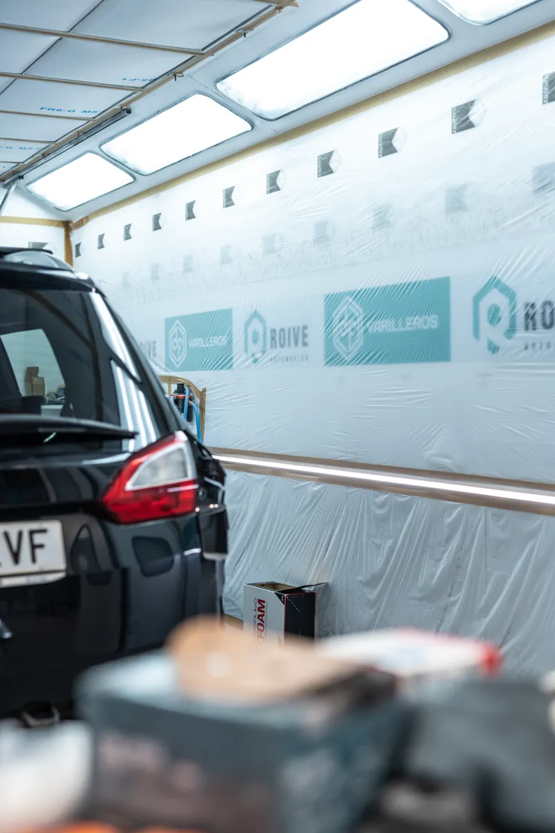 Cabina de pintura con los rótulos de Roive Automoción y DF Varilleros